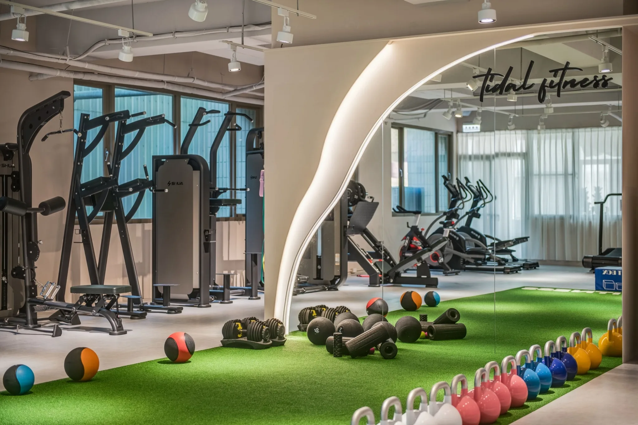 TIDAL Fitness 功能訓練區全景,包含草皮跑道、自由重量與訓練器材